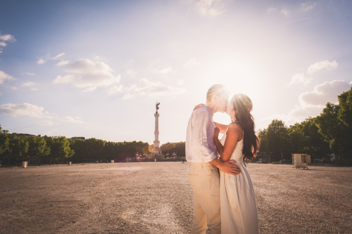 Couple échangeant un baiser romantique à la Place des Quinconces, immortalisé par un photographe de mariage de Bordeaux