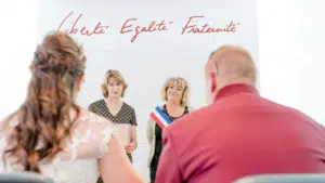 Cérémonie de mariage civile en France avec les mots "Liberté, Égalité, Fraternité" en arrière-plan