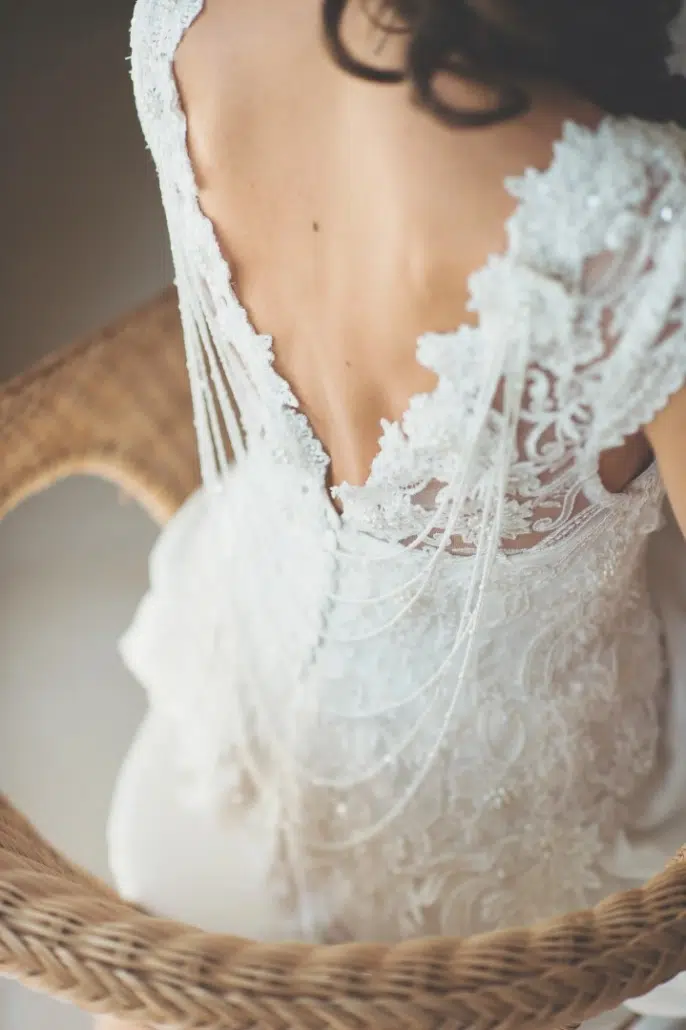 Dos d'une mariée dévoilant les détails délicats de sa robe de dentelle, une image poétique capturée par lafocaledolga en Gironde.